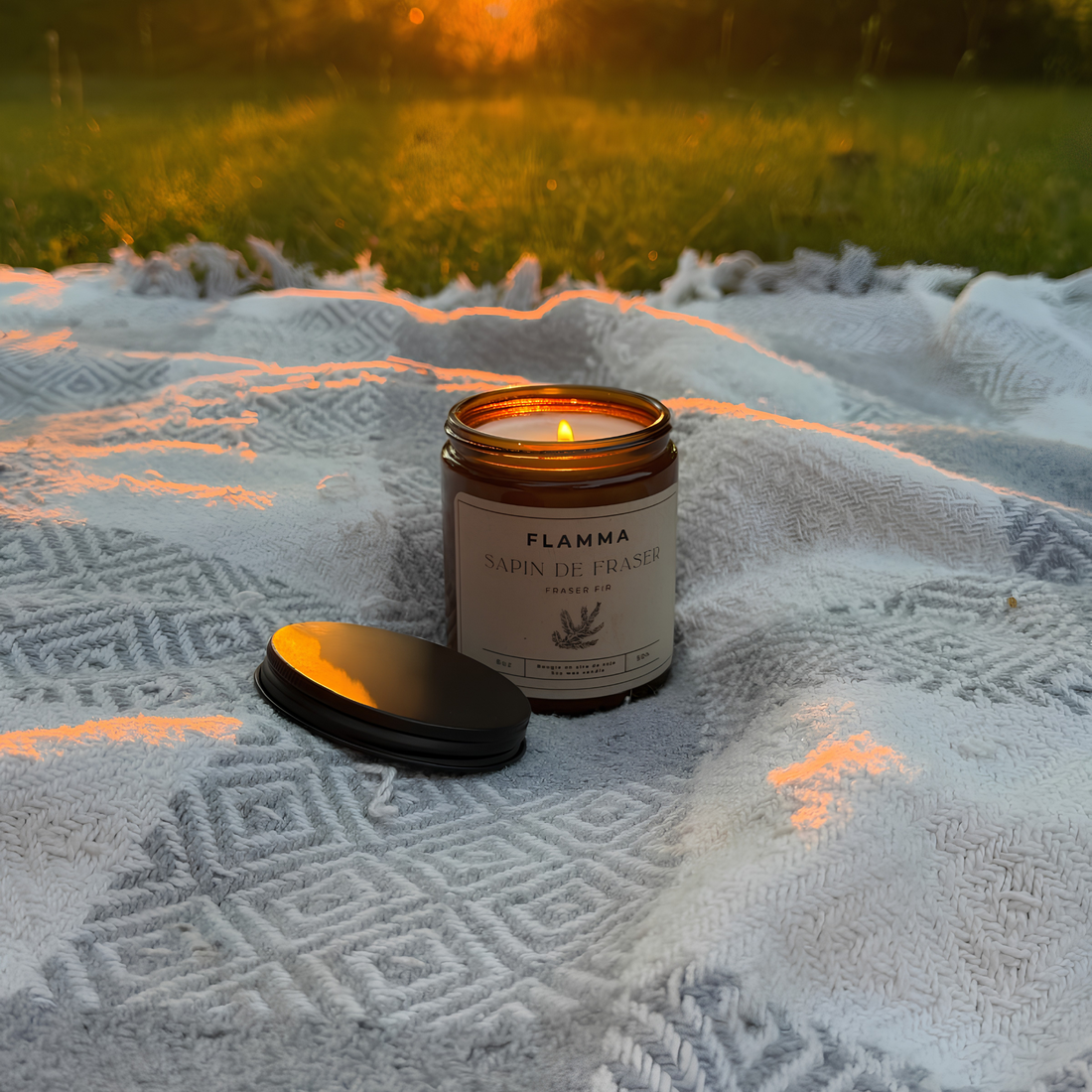Bougie parfumée FLAMMA en plein air sur une couverture enneigée